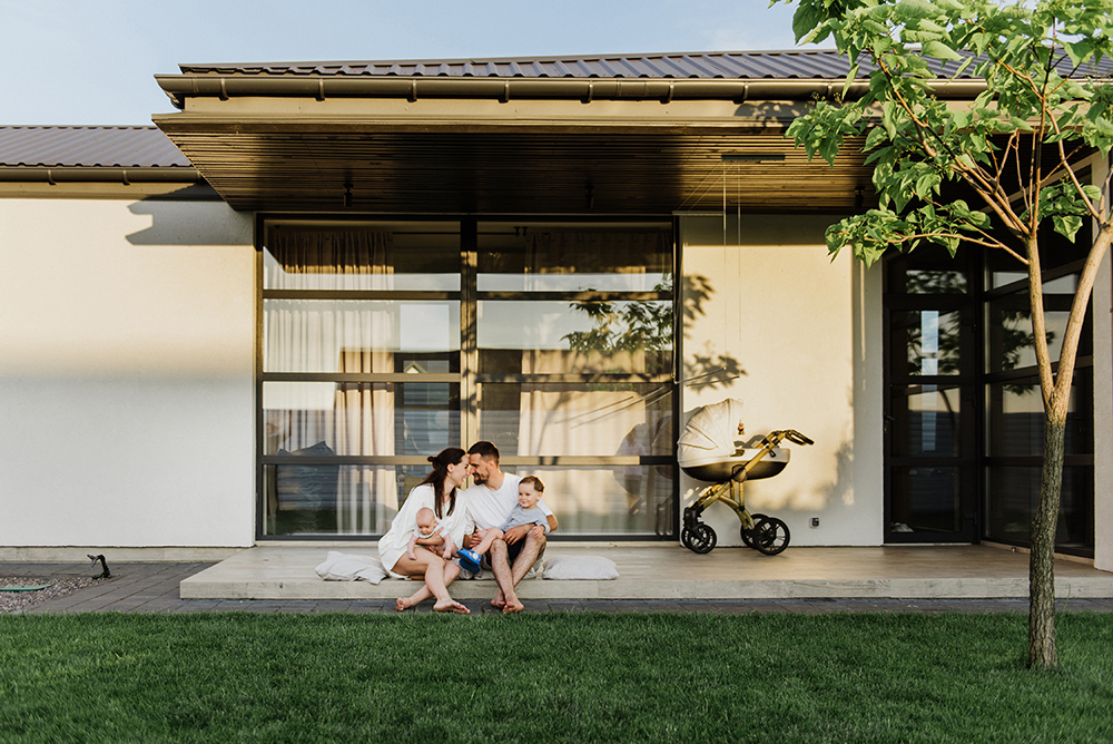 young family in front of house