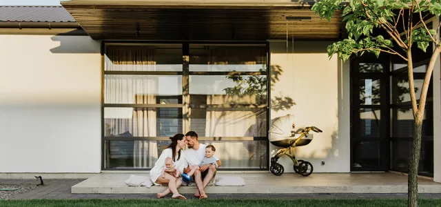 young family in front of house